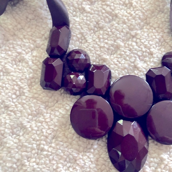 Brown bead necklace with ribbon tie closure.